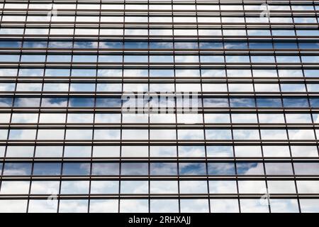 Regardant vers le haut à plusieurs fenêtres sur un bloc de bureaux reflétant le ciel Banque D'Images