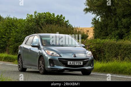 Woburn, Lits, Royaume-Uni - 19 août 2023 : 2012 Mazda 3 voiture voyageant sur une route de campagne anglaise. Banque D'Images