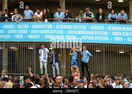 Les supporters de Manchester City attendent que le bus de l'équipe arrive avant le match de Premier League à l'Etihad Stadium, Manchester. Date de la photo : Samedi 19 août 2023. Banque D'Images