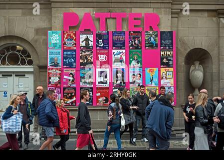 Les touristes de frange marchent par des affiches faisant de la publicité au Gilded Balloon Patter Hoose sur Chambers Street, Édimbourg, Écosse, Royaume-Uni. Banque D'Images
