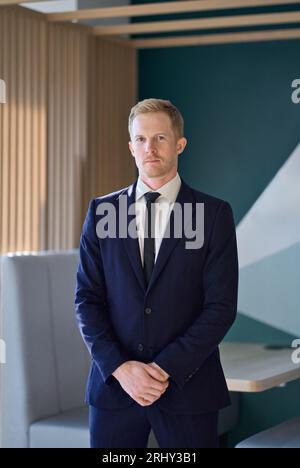 Jeune homme d'affaires professionnel confiant debout dans le bureau. Portrait vertical. Banque D'Images