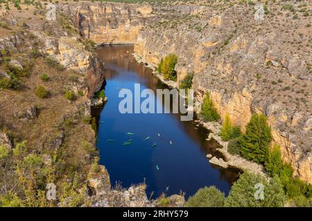 Réserve naturelle de Hoces del Rio Duraton (Parque Natural de las Hoces del Río Duratón) avec falaises verticales calcaires, eau bleue et kayaks colorés. Banque D'Images