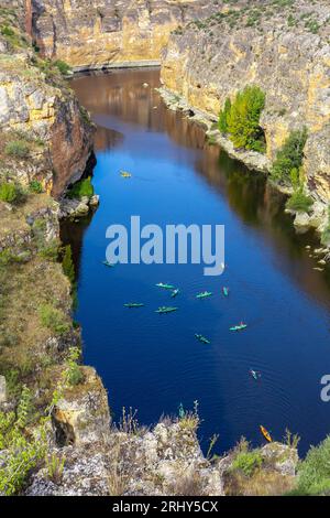 Réserve naturelle de Hoces del Rio Duraton (Parque Natural de las Hoces del Río Duratón) avec falaises verticales calcaires, eau bleue et kayaks colorés. Banque D'Images