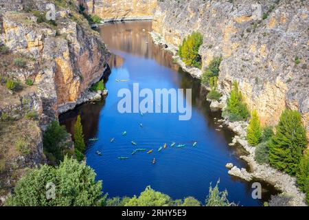 Réserve naturelle de Hoces del Rio Duraton (Parque Natural de las Hoces del Río Duratón) avec falaises verticales calcaires, eau bleue et kayaks colorés. Banque D'Images