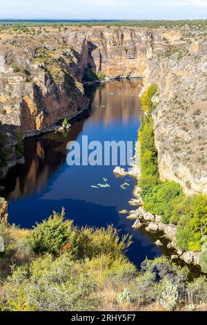 Réserve naturelle de Hoces del Rio Duraton (Parque Natural de las Hoces del Río Duratón) avec falaises verticales calcaires, eau bleue et kayaks colorés. Banque D'Images