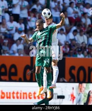 Augsbourg, Allemagne. 19 août 2023. Maximilian Bauer d'Augsbourg défie Alassane Plea (avant) de Moenchengladbach lors du match de football allemand de première division Bundesliga entre le FC Augsbourg et le Borussia Moenchengladbach à Augsbourg, en Allemagne, le 19 août 2023. Crédit : Philippe Ruiz/Xinhua/Alamy Live News Banque D'Images