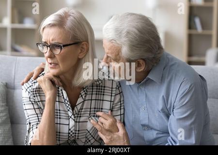 Vieux mari inquiet embrassant une femme anxieuse atteinte de troubles mentaux Banque D'Images