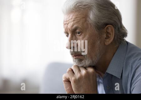 Un vieil homme retraité attentionné regardant loin Banque D'Images