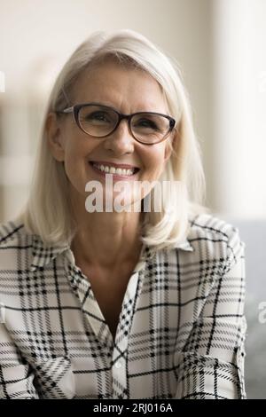 Heureuse femme âgée confiante dans les lunettes portrait de tête verticale Banque D'Images