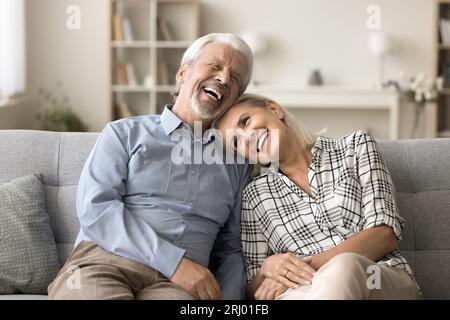 Femme mature reposant sur un canapé avec la tête sur l'épaule du mari Banque D'Images