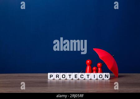 Parapluie et figurines de poupée en bois. Concept de couverture d'assurance. Banque D'Images