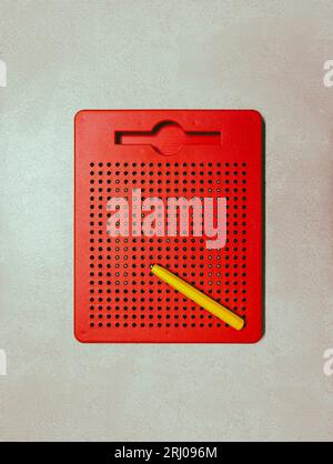 un bloc de dessin magnétique rouge éducatif ou un tableau avec stylo pour les activités d'esquisse et d'apprentissage des enfants isolés Banque D'Images