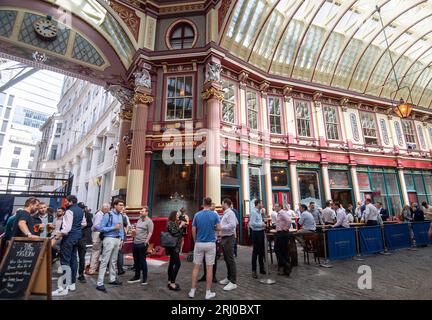 Londres, Royaume-Uni. 10 août 2023. Employés de bureau buvant devant la Lamb Tavern dans le Leadenhall Market dans la ville de Londres. Wikapédia déclare que « c'est l'un des plus anciens marchés de Londres, datant du 14e siècle, et est situé dans le centre historique du quartier financier de la City of London ». Crédit : Maureen McLean/Alamy Banque D'Images