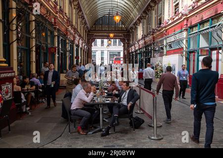 Londres, Royaume-Uni. 10 août 2023. Les employés de bureau déjeunent à l'extérieur au Leadenhall Market dans la ville de Londres. Wikapédia déclare que « c'est l'un des plus anciens marchés de Londres, datant du 14e siècle, et est situé dans le centre historique du quartier financier de la City of London ». Crédit : Maureen McLean/Alamy Banque D'Images