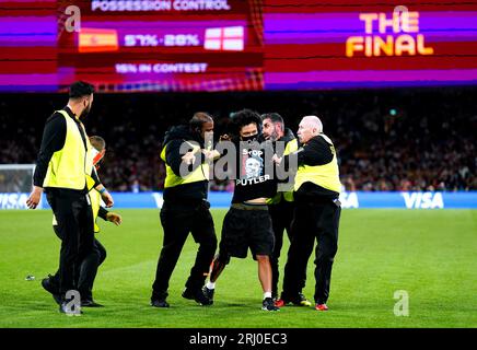 Un envahisseur de terrain est retiré par la sécurité lors du match final de la coupe du monde féminine de la FIFA au Stadium Australia, Sydney. Date de la photo : dimanche 20 août 2023. Banque D'Images