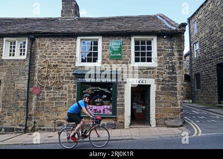 Cyclslist passant par le plus ancien Sweet Shop en Angleterre, Pateley Bridge Banque D'Images