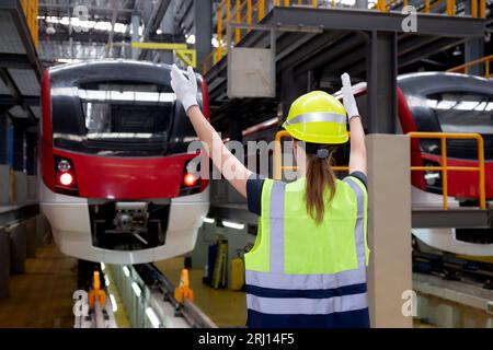 Jeune femme ingénieur caucasien ou travailleur signal et vérification du train électrique pour la planification de l'entretien dans la gare, le transport et l'infrastructure, inspecter Banque D'Images