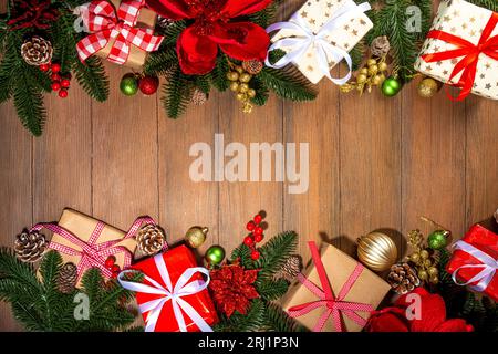 Noël traditionnel, vacances du nouvel an arrière-plan avec branches d'arbre de Noël, baies rouges d'hiver, fleurs de poinsettia, boîtes-cadeaux, sur le dos en bois Banque D'Images