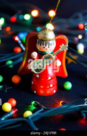 Ange en bois avec guitare et lumières de noël Banque D'Images