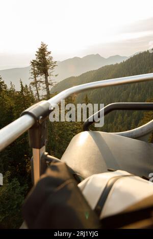 Vue panoramique sur le coucher du soleil depuis le télésiège, capturant la beauté de Grouse Mountain avec Burrard Inlet visible Banque D'Images