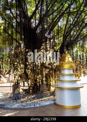 Une petite maquette dorée du temple et un arbre orné de feuilles d'or suspendues font honneur à Wat Saket, le Mont d'Or, à Bangkok, Thaïlande. Banque D'Images