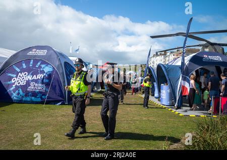 Deux policiers traversent l'exposition militaire aux côtés de l'Eastbourne Airbourne, un spectacle aérien international annuel. Le spectacle dure quatre jours ea Banque D'Images