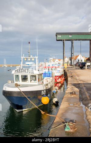 Bateaux de pêche amarrés dans le port de Wells à côté de la mer sur la côte nord de Norfolk à marée haute un soir d'août 2023. Banque D'Images