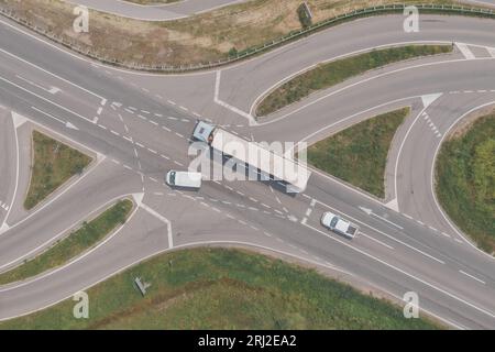 Plan aérien d'un gros semi-camion, d'une camionnette et d'une camionnette à l'intersection de la route du drone pov, directement au-dessus Banque D'Images