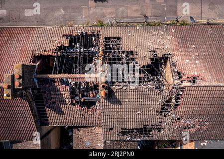 Vue aérienne directement au-dessus d'une rangée de maisons mitoyennes brûlées et abandonnées dans le nord de l'Angleterre avec des dommages au toit après un incendie de maison Banque D'Images