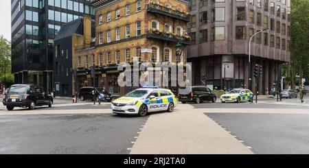 Londres, Royaume-Uni - 29 juillet 2023 ; voitures de police du London Metropolitan à grande vitesse avec des feux bleus clignotant à l'intersection de la rue Banque D'Images