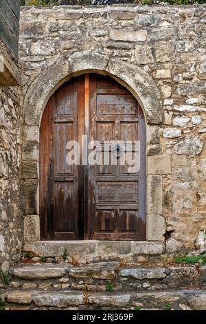 Vieille porte en bois avec linteau voûté en pierre dans un ancien manoir dans la vieille ville de Rethymno, en Crète, Grèce, Europe. Banque D'Images