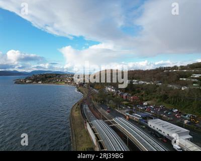 Une vue aérienne d'une autoroute et d'un train traversant une large rivière, avec une chaîne de montagnes en arrière-plan Banque D'Images