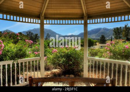 Vue sur le magnifique jardin luxuriant de l'intérieur du gazebo boisé Banque D'Images