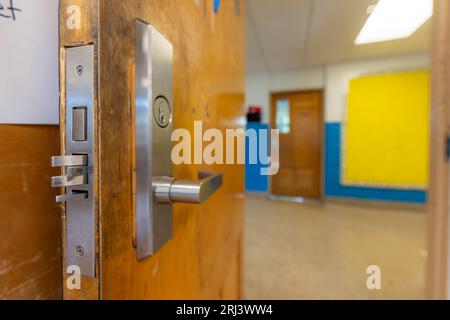 Ouvrez la porte de la salle de classe avec une nouvelle quincaillerie de porte avec des verrous de sécurité pour un verrouillage. Banque D'Images