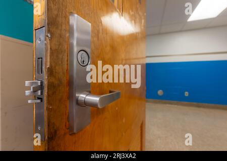 Ouvrez la porte de la salle de classe avec une nouvelle quincaillerie de porte avec des verrous de sécurité pour un verrouillage. Banque D'Images