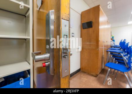 Ouvrez la porte de la salle de classe avec une nouvelle quincaillerie de porte avec des verrous de sécurité pour un verrouillage. Banque D'Images