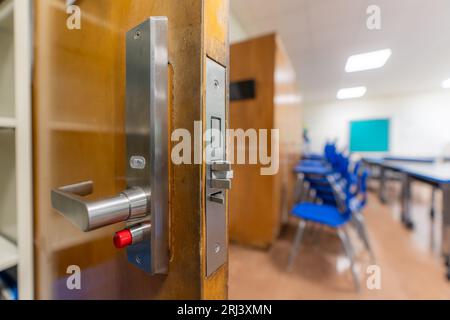 Ouvrez la porte de la salle de classe avec une nouvelle quincaillerie de porte avec des verrous de sécurité pour un verrouillage. Banque D'Images