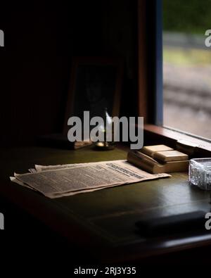 Un bureau en bois avec des journaux éparpillés dessus de manière ordonnée et organisée Banque D'Images