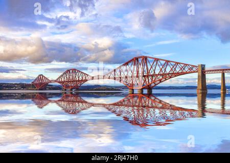 Le Forth Rail Bridge, l'un des monuments les plus célèbres d'Écosse, avec un reflet dans le Firth of Forth. Conçu par les ingénieurs Sir John Fowler et... Banque D'Images