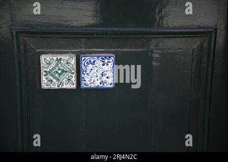 Porte en bois vert antique décorée avec des carreaux de céramique émaillée majolique à Scicli Sicile, Italie. Banque D'Images