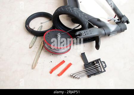 Scooter électrique démonté, crevaison de roue et remplacement par une nouvelle roue, réparation de transport électrique et services Banque D'Images