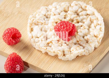 Gâteau de riz et framboises sur une planche de cuisine en bambou, vue de dessus, gros plan Banque D'Images