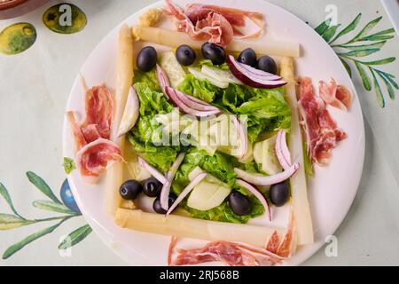 Salade de laitue, asperges, olives noires, jambon ibérique, concombre et oignon Banque D'Images