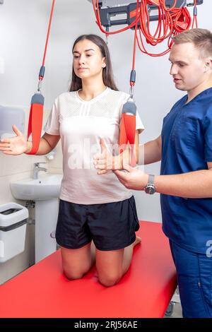 Physiothérapeute assiste la patiente dans un centre de fitness moderne. Banque D'Images