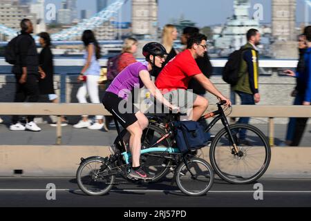 Une femme qui fait la navette sur un vélo pliant Brompton à travers London Bridge, Londres, Royaume-Uni. 7 juin 2023 Banque D'Images