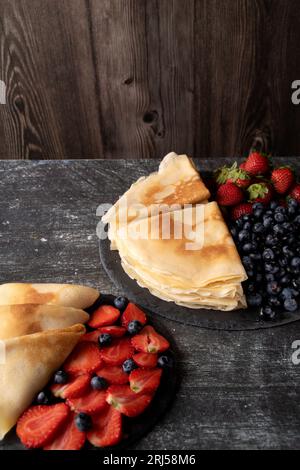 photo fraises, myrtilles et crêpes fines de sucre en poudre sur des assiettes Banque D'Images