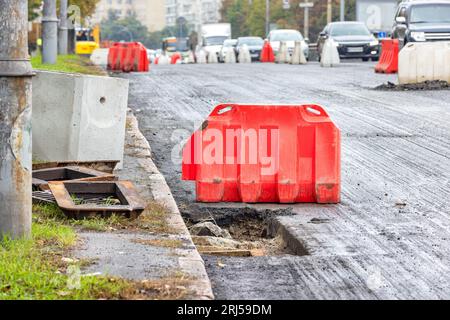 Remplacement des anciennes écoutilles d'égout pluvial sur le côté de la chaussée d'une route urbaine. Banque D'Images