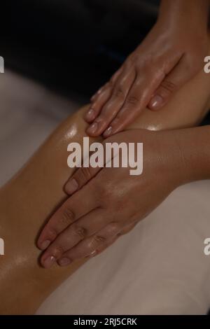 Le maître fait un massage des pieds avec de l'huile essentielle en gros plan Banque D'Images