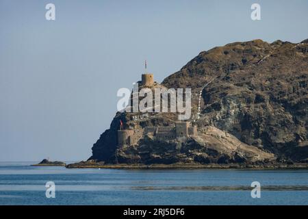 Un château majestueux se dresse au sommet d'une colline surplombant la magnifique côte d'Oman au Moyen-Orient Banque D'Images