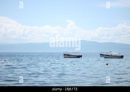 Une vue pittoresque sur le lac Ohri en Macédoine, avec plusieurs petits bateaux flottant sur les eaux tranquilles du lac Banque D'Images